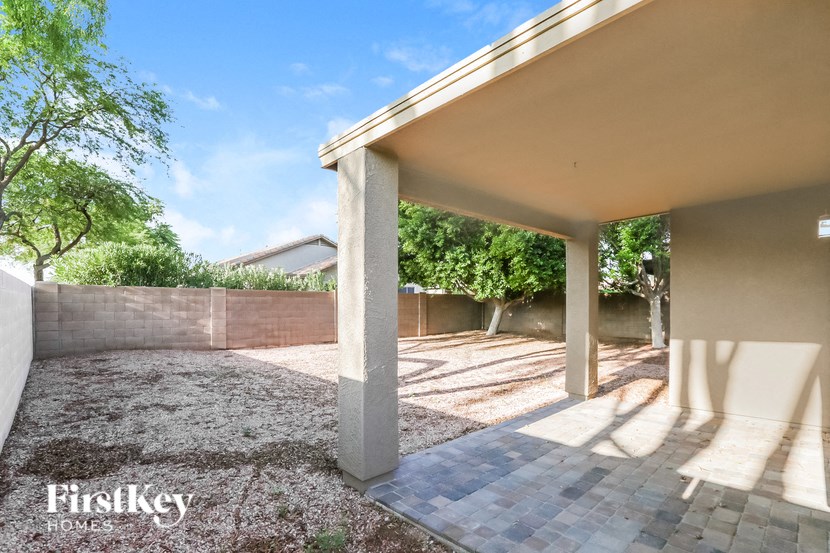A patio area with a concrete floor and pillars.