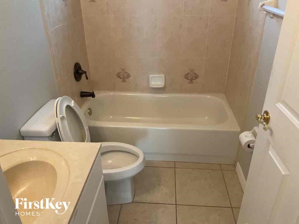 A white toilet and bathtub in a bathroom.