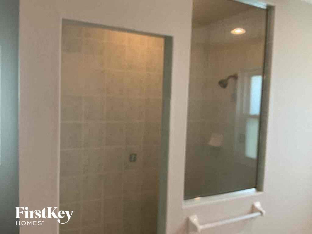 A shower stall with a glass door and a white frame.