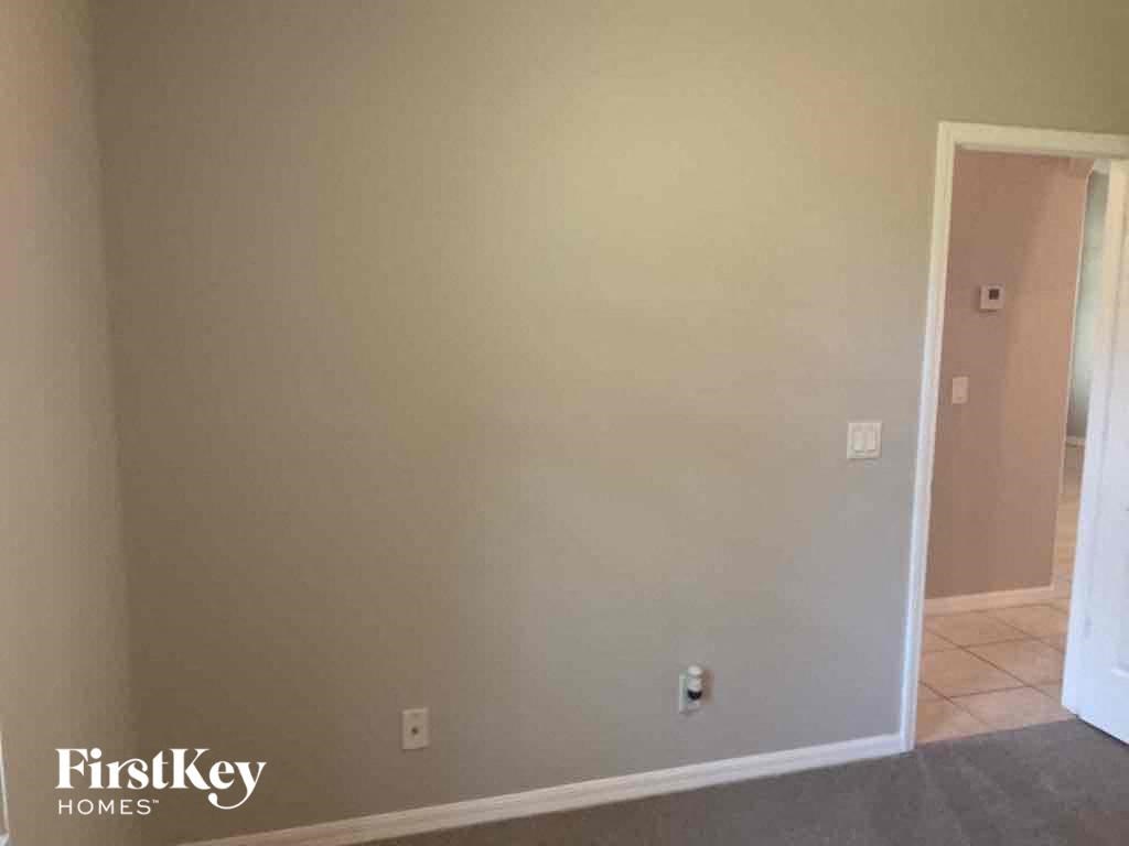 A room with a white door and a wall with a FirstKey Homes logo.