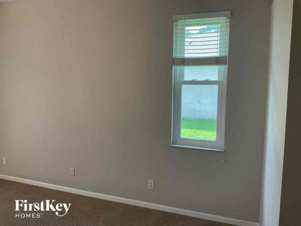 A room with a window showing a green lawn outside.