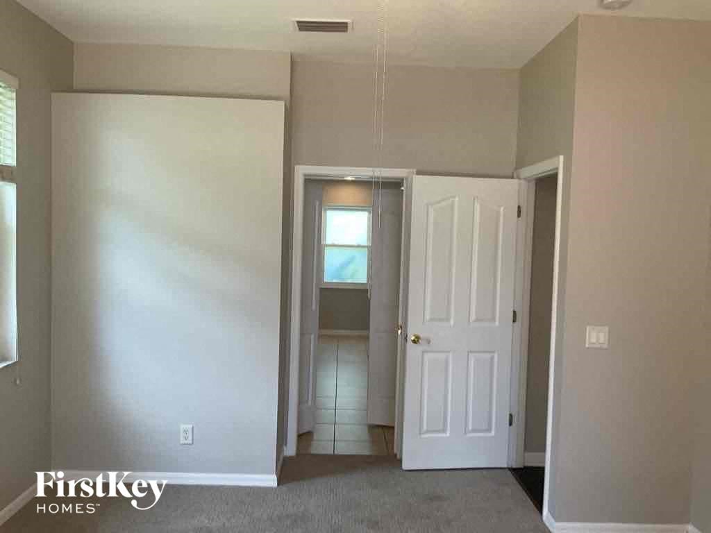 A room with a white door and a window on the left.