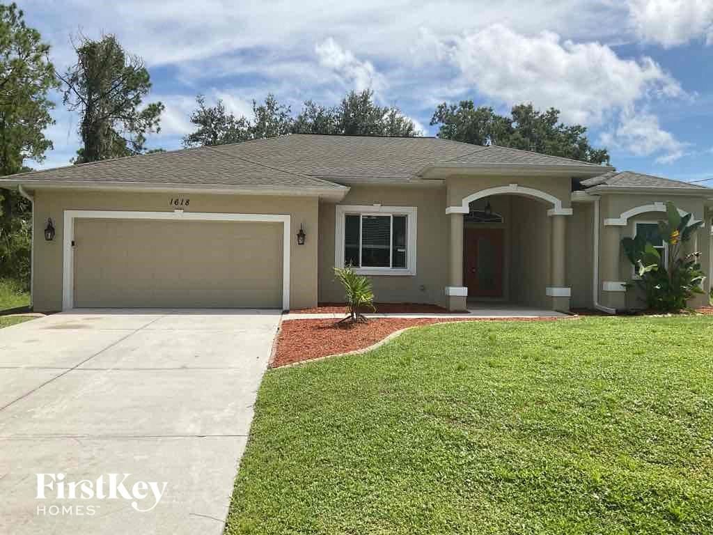 A house with a garage and a driveway in front of it.