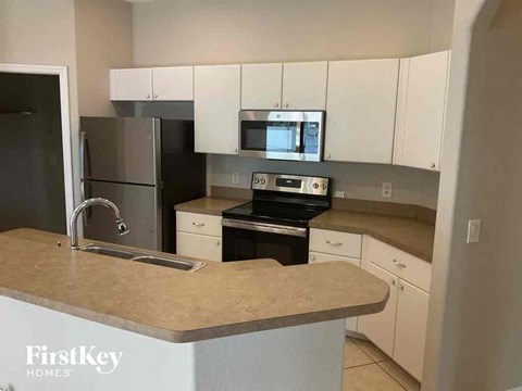 A kitchen with a black stove top oven and a black refrigerator.