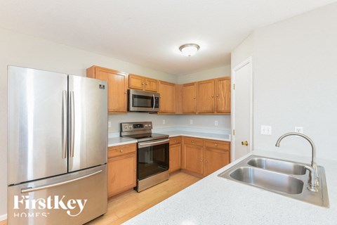 A kitchen with a stainless steel refrigerator and wooden cabinets.