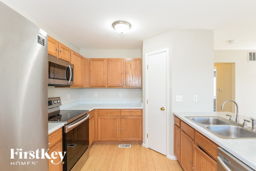 A kitchen with wooden cabinets and a stainless steel refrigerator.