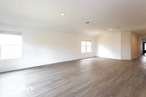 an empty living room with white walls and wood floors