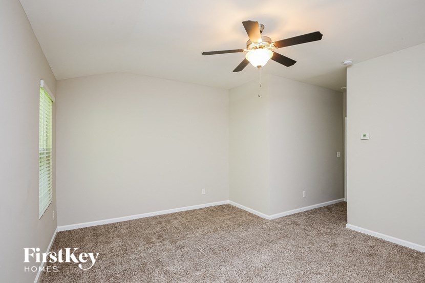 a bedroom with a ceiling fan and a carpeted floor