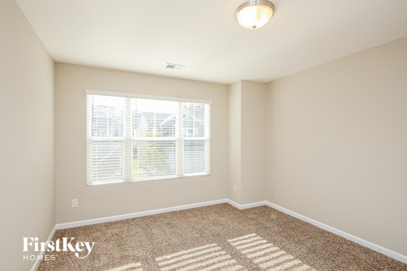 a spacious room with carpet and a large window
