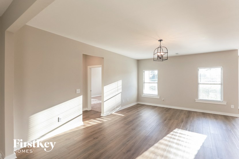 an empty living room with white walls and wood floors