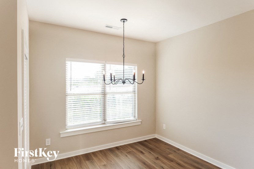 a living room with a large window and a chandelier