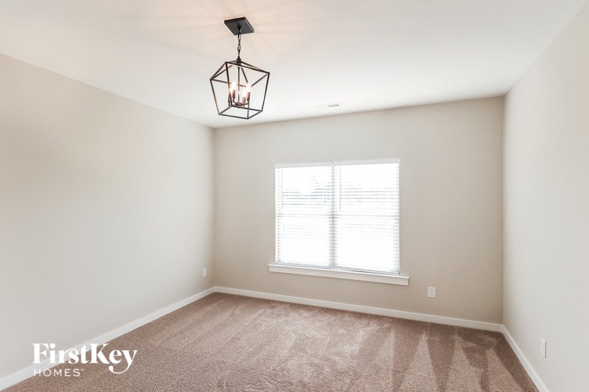an empty room with a window and a chandelier