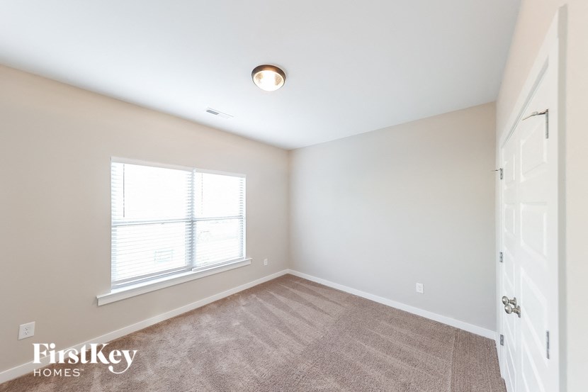a bedroom with a large window and a white door