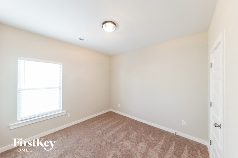 a bedroom with carpet and a window and a door