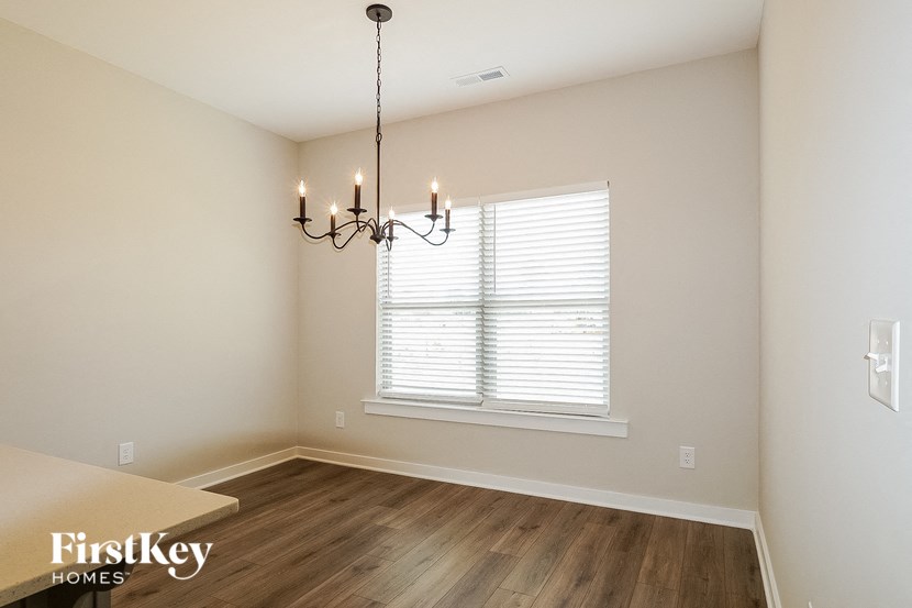 a dining room with a window and a chandelier