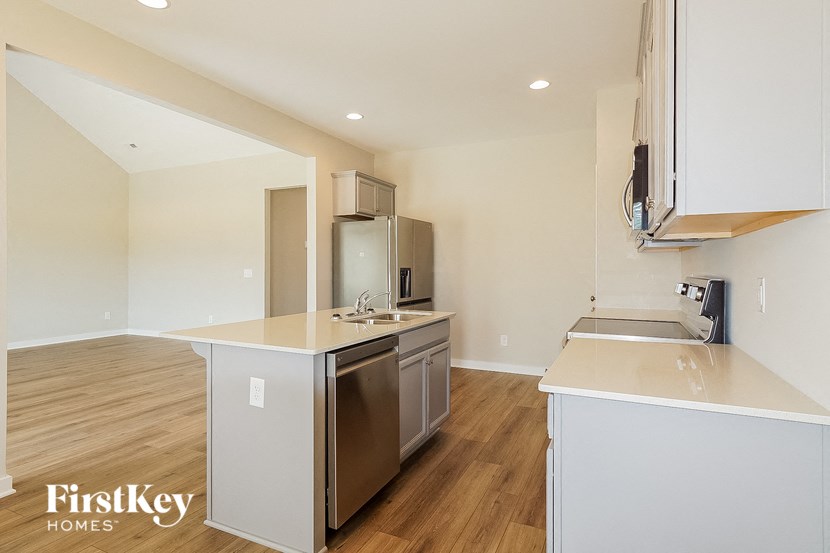 a white kitchen with a stainless steel refrigerator and a sink