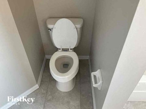 A white toilet in a small bathroom.
