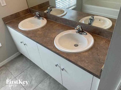 A bathroom vanity with two sinks and a mirror.