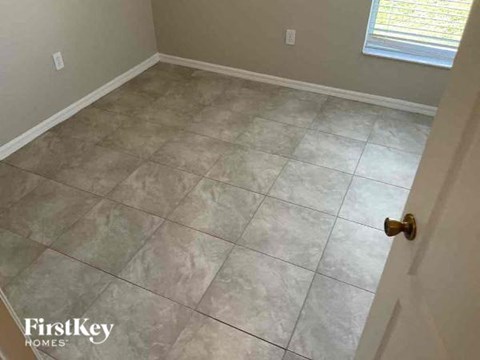 A room with a tile floor and a door on the right side.
