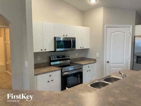 A kitchen with a stove top oven and microwave built into the cabinetry.