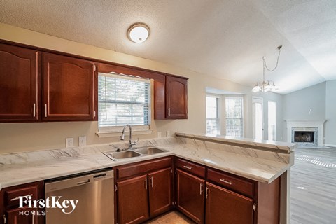 A kitchen with wooden cabinets and a marble countertop.