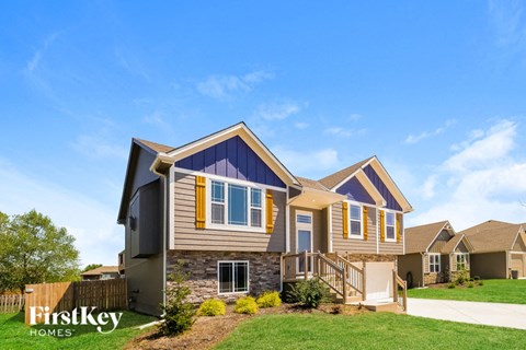 a home with a stone exterior and a blue roof