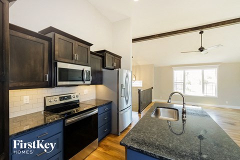 a kitchen with black cabinets and stainless steel appliances