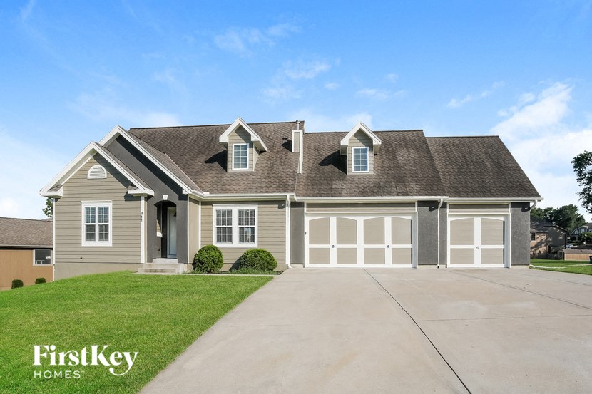 A house with a garage and a driveway in front of it.