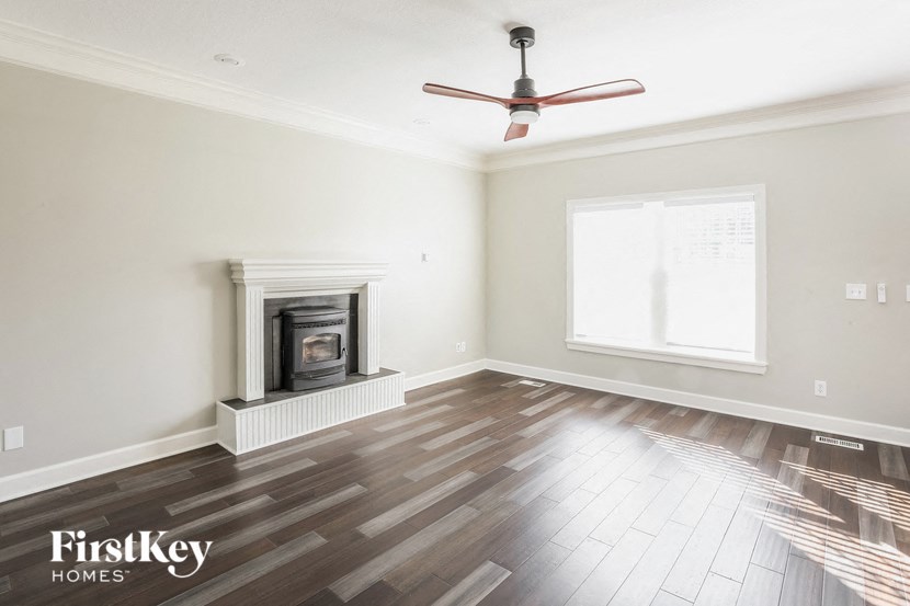 A room with a fireplace and a fan on the ceiling.