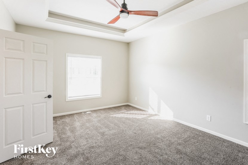 A room with a ceiling fan and a window.