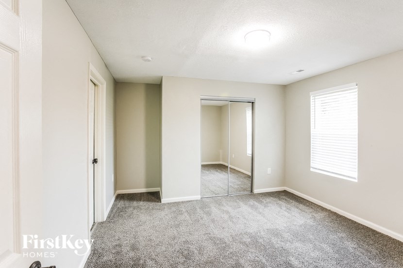 A spacious room with a carpeted floor and a sliding glass door.