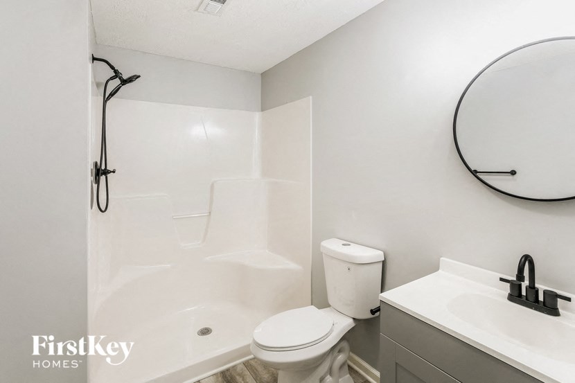 A bathroom with a toilet, sink, and shower.