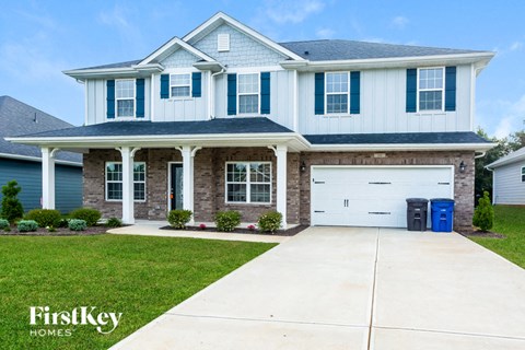 a white house with blue shutters and a white garage door