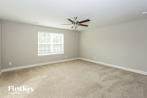 a bedroom with carpet and a ceiling fan