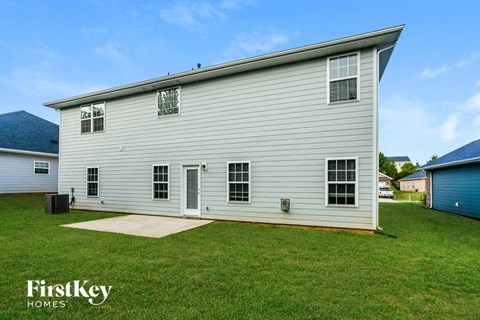 a white house with white siding and a grassy yard