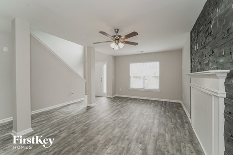 A spacious room with a ceiling fan and wooden flooring.