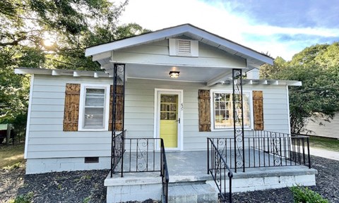 a small white house with a yellow door