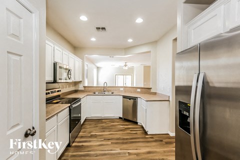 A kitchen with wooden floors and stainless steel appliances.