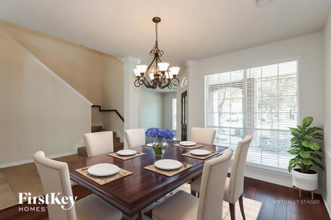 A dining room with a wooden table set for four.