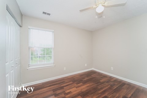 a living room with wood flooring and a ceiling fan