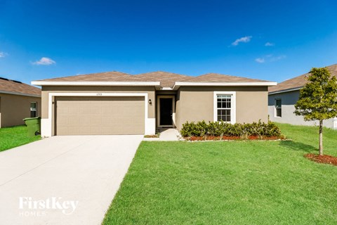 a beige house with a driveway and a garage door