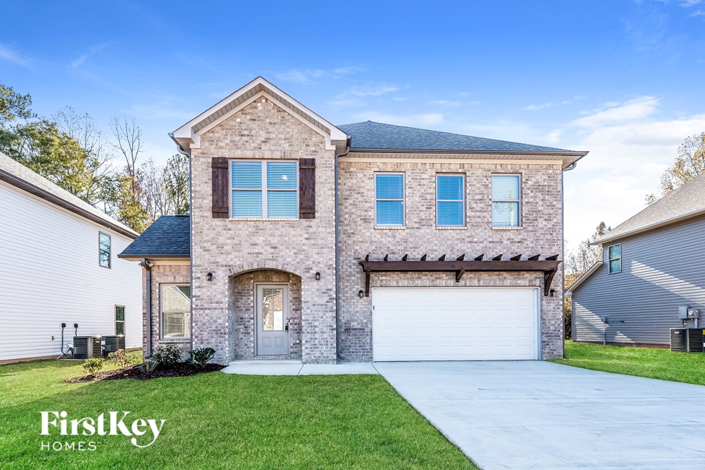 A house with a garage and a driveway in front of it.