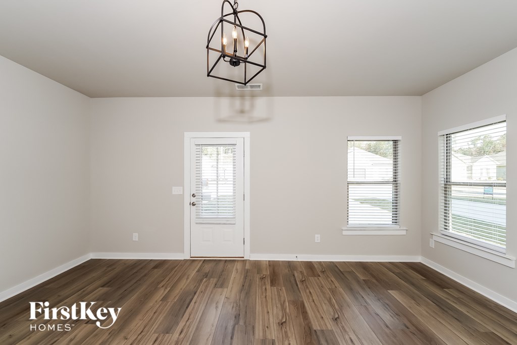 A room with wooden floors and a chandelier hanging from the ceiling.