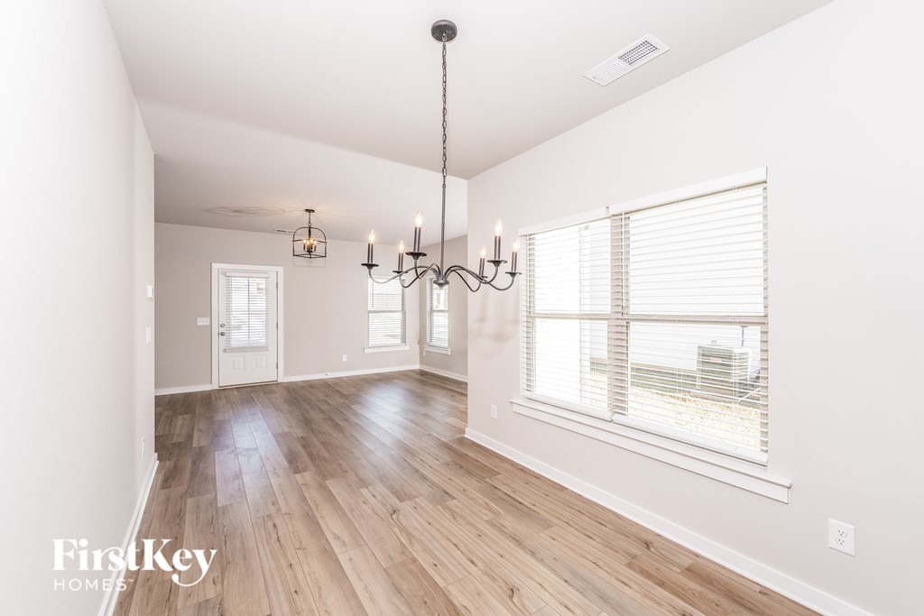 A well-lit room with wooden floors and a chandelier.
