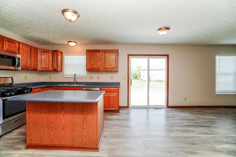 A kitchen with wooden cabinets and a large island.