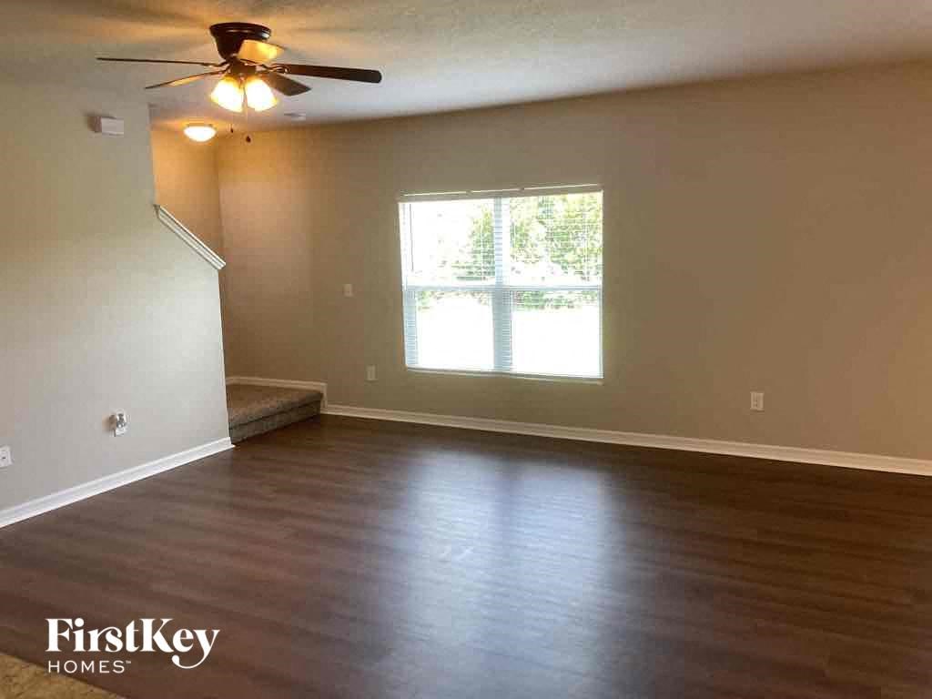 A room with a ceiling fan and a window.