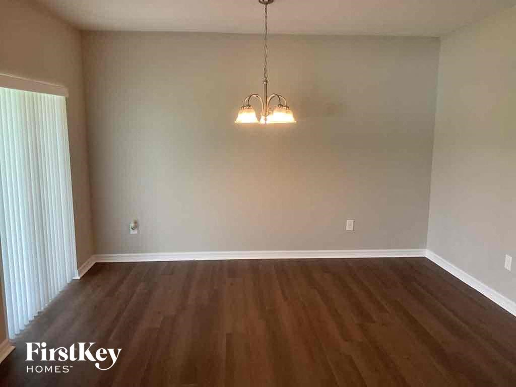 A room with wooden floors and a hanging light fixture.