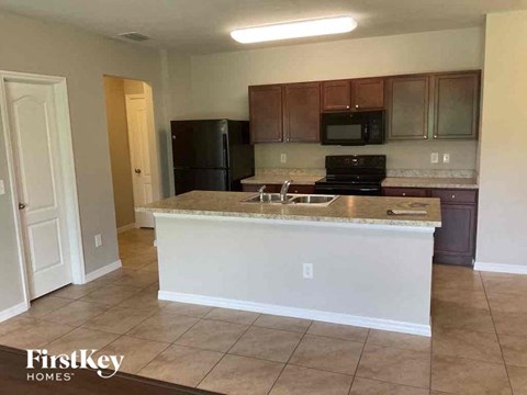 A kitchen with a white counter and brown cabinets.