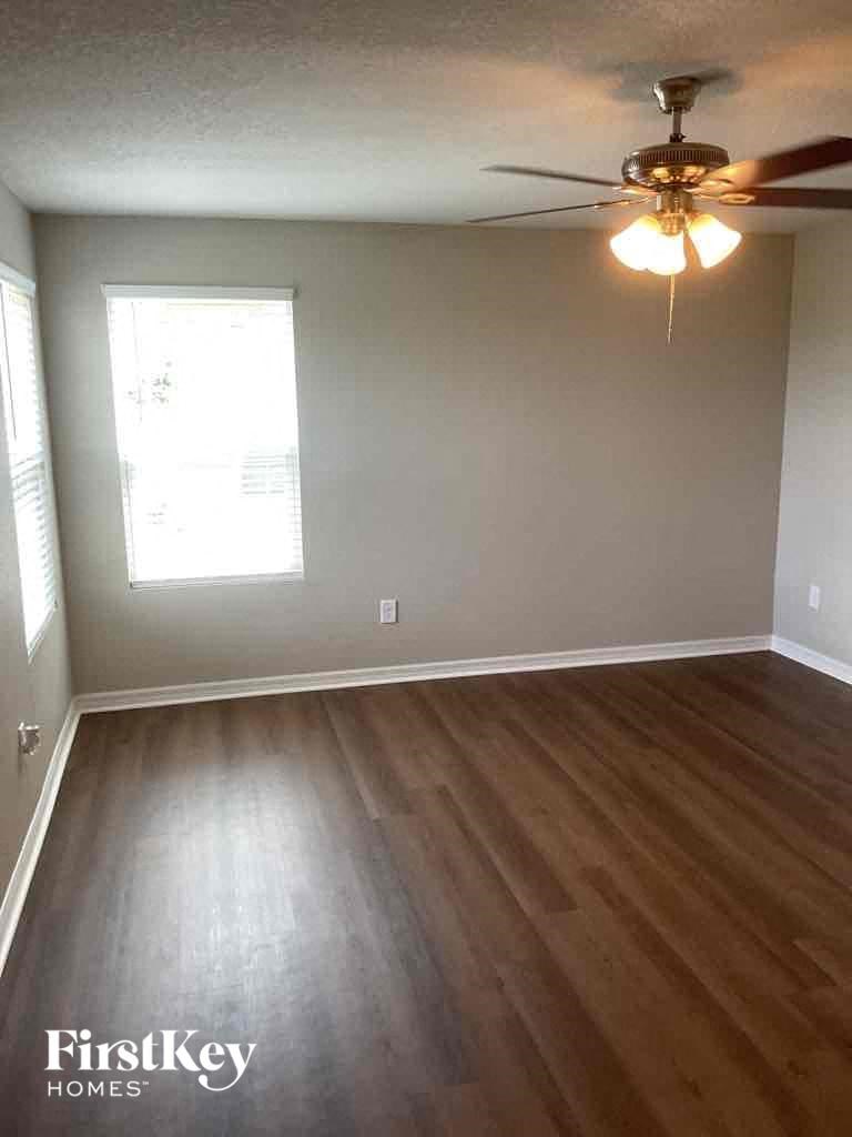 A room with wooden floors and a ceiling fan.