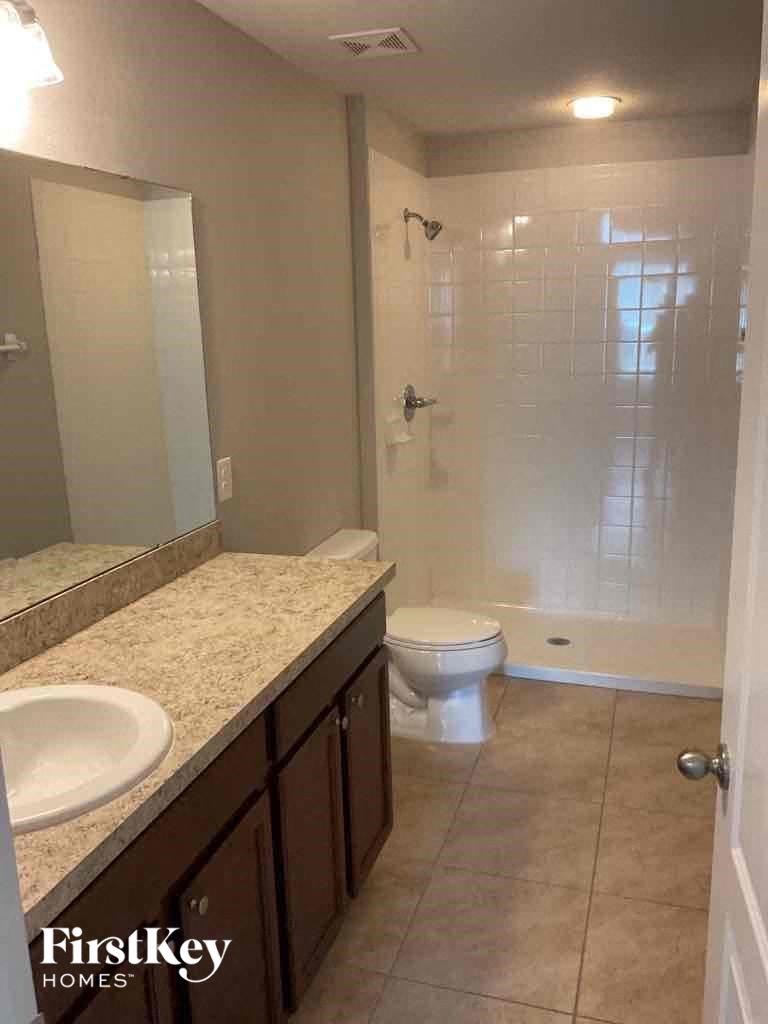 A bathroom with a toilet, sink, and shower.